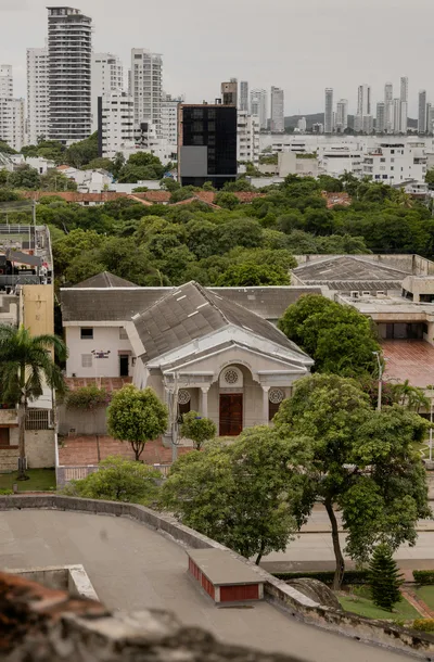 Aerial view of historical and modern architecture in Cartagena, Colombia with lush greenery.