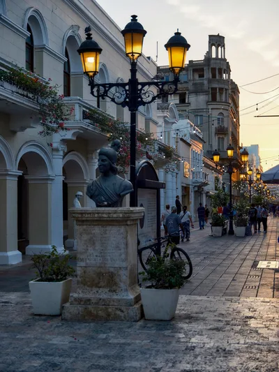 Charming evening street scene in Santo Domingo, featuring classic architecture and vibrant street life.