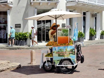Juice vendor cart with oranges in Cartagena, Colombia street.