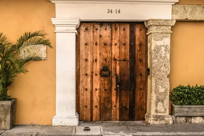 Rustic wooden door in a colonial-style building in Cartagena, Colombia.