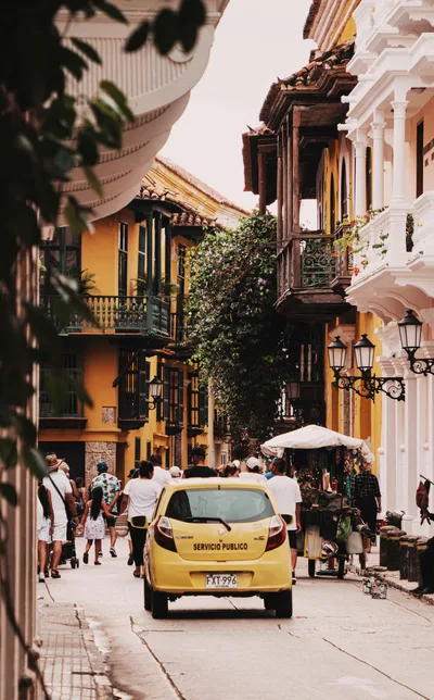 Vibrant scene of a lively street in Cartagena with colonial architecture.