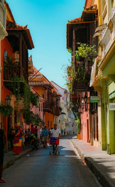 Vibrant street scene in Cartagena's historic district with colonial architecture and locals.