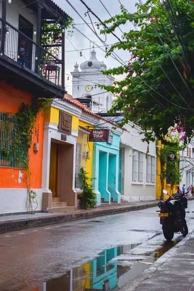 Vibrant street view showcasing colonial architecture in Santa Marta after rain.